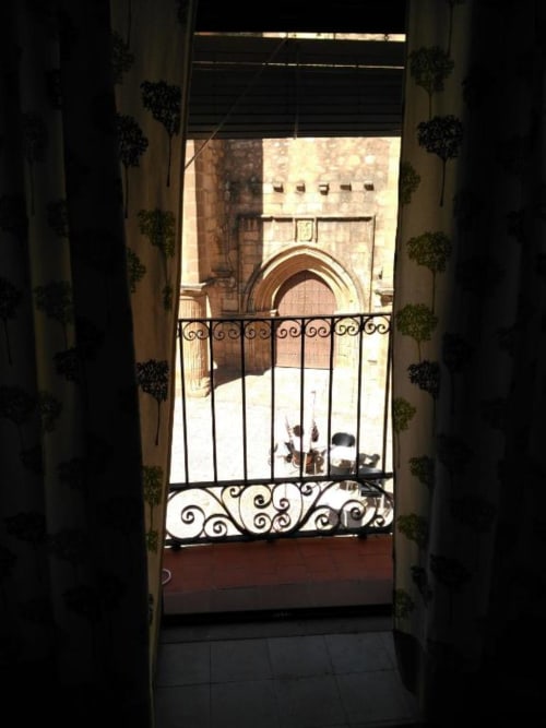 Elegante balcón de hierro forjado en La Machacona con vistas a la Plaza de Santiago en Cáceres histórico