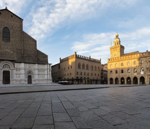 Piazza Maggiore in Bologna with historic medieval buildings and church facades, home to Living Palazzi Storici hotel