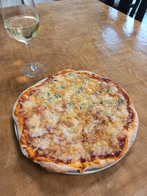 Gourmet pizza with white wine at Le Clos du Thoronet restaurant in Le Thoronet, France