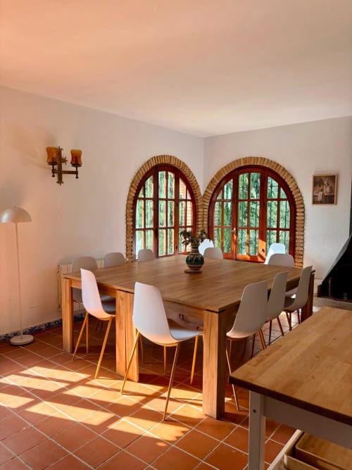 Comedor de Holiday Dreams Ronda con mesa de madera, sillas blancas y puertas de arco de ladrillo con vistas a las montañas