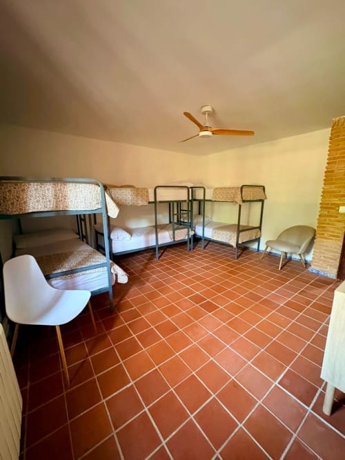 Amplia habitación de dormitorio en Holiday Dreams Ronda con literas, piso de baldosa de terracota y ventilador de techo