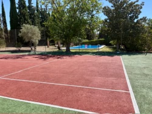 Cancha de tenis en Holiday Dreams Ronda con piscina y cipreses en Ronda, España