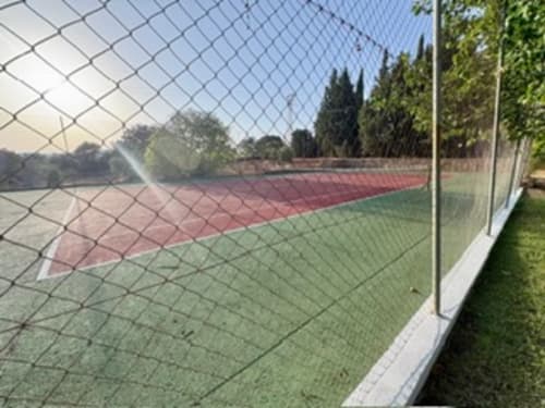 Pistas de tenis en Holiday Dreams Ronda con arcilla roja y canchas duras verdes, rodeadas de cipreses y cercos