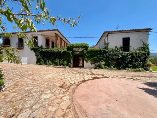 Sueños navideños: patio de Ronda en España con edificios coloniales blancos, paredes cubiertas de hiedra y vistas a las montañas