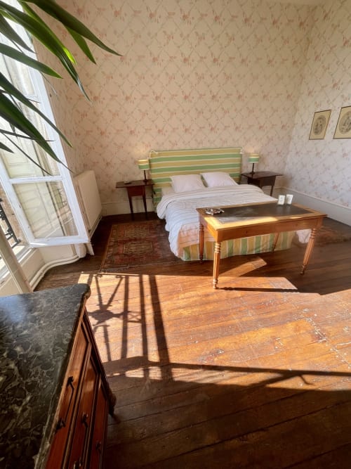 Charming bedroom at Château de Vaux Morvan B&B in Étang sur Arroux with striped headboard, wooden furniture, and classical