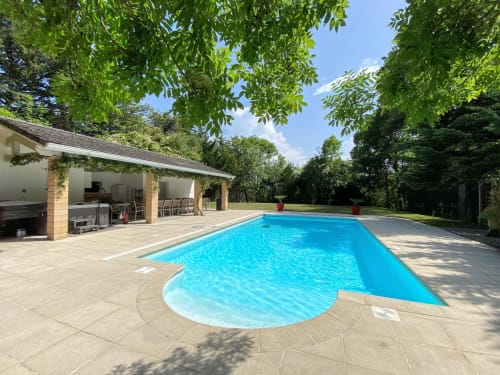 Piscina de la finca con terraza soleada, pabellón junto a la piscina y frondosos jardines en Domaine de Bize, Mirepoix