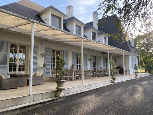 Elegantes französisches Herrenhaus mit weißer Veranda, blauen Fensterläden und Steinpatio im Domaine de Bize, Mirepoix, Ariège