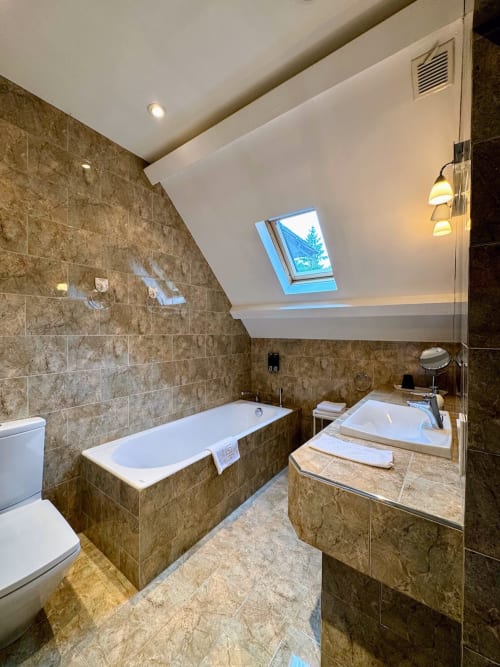 Luxuriöses Badezimmer mit Badewanne, begehbarer Dusche und gefliesten Wänden im Domaine de Bize in Mirepoix