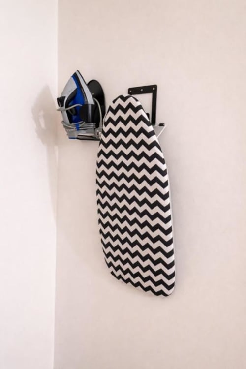 Wall-mounted ironing board with chevron pattern and blue iron at Catherines House Kings Cross, London