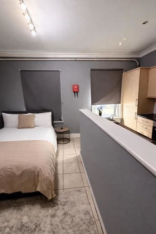 Modern Room 1 at Catherines House Kings Cross, London featuring bed, kitchenette, and grey wall decor