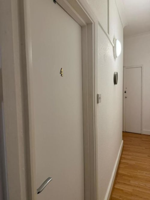 Hallway at Catherines House Kings Cross with white doors numbered 4, wooden flooring, and modern fixtures
