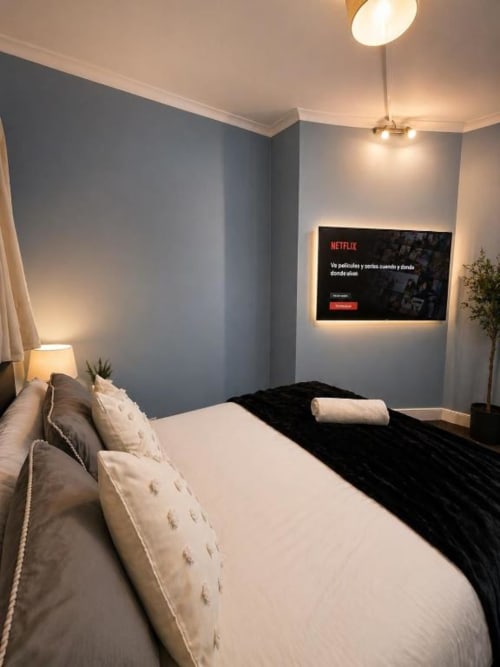 Modern bedroom at Catherines House Kings Cross with bed, Netflix TV, mood lighting, and blue accent wall