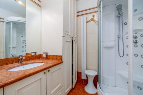 Salle de bain luxueuse à la Maison Josephine de Riviera Home à Roquebrune-Cap Martin avec carrelage terracotta, meuble vasque en bois et douche à l'italienne