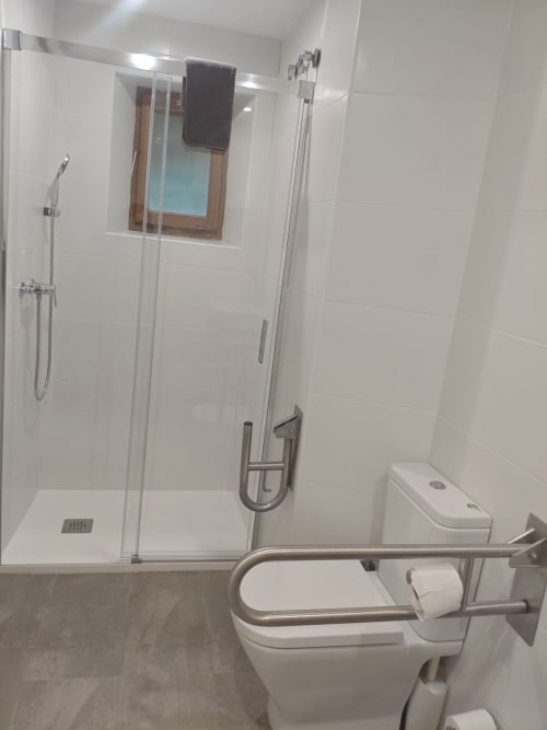 Bany modern accessible a l'apartament Séncies Can Girona de Sitges amb dutxa sense escalons, barres de suport i vàter