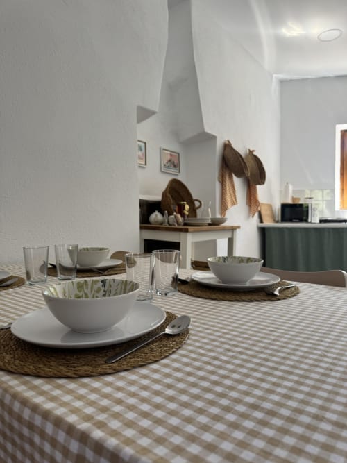 Menjador modern a l'apartament Séncies Can Girona de Sitges amb taula elegant servida i parets blanques