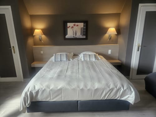 Modern bedroom at Les Alisiers B&B in Nadrin, Houffalize with queen bed, warm lighting, and minimalist décor