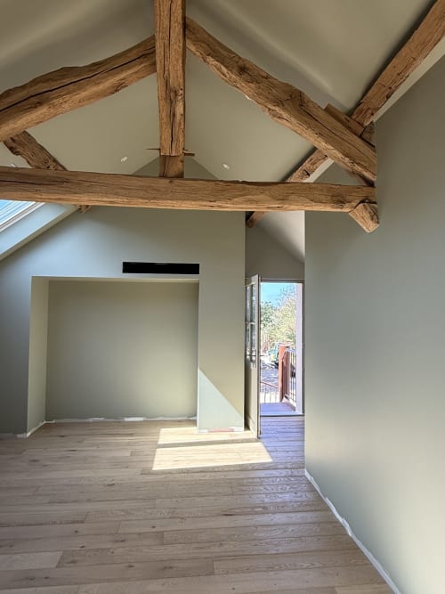 Chambre La Fougère lumineuse à La Grange Aux Etangs avec poutres apparentes, parquet et porte donnant sur le jardin