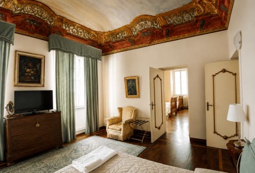 Camera elegante al Bresbot B&B di Bressana con soffitto ornato, vista giardino, TV e arredi d'epoca