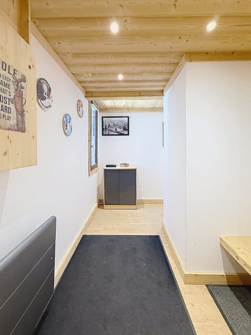 Modern wooden hallway in L'AKWABA duplex at Les Tanières de Montgenèvre with black mat, storage cabinet, and ski-accessible