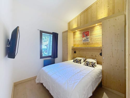 Modern bedroom with wooden walls, double bed, window with mountain view in Les Tanières de Montgenèvre, Montgenevre