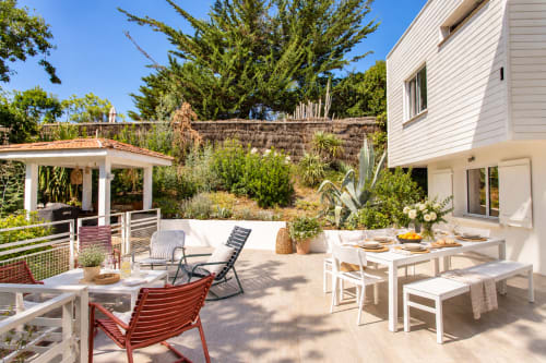 Patio de la Villa Cloudbreak avec table à manger, transats et vue sur le jardin luxuriant à Lège Cap Ferret