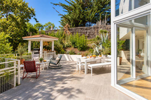 Terrasse ensoleillée de la Villa Cloudbreak avec table à manger, chaises longues, gazebo et portes modernes à Lège Cap Ferret