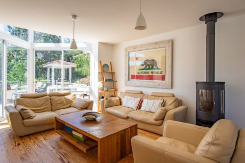 Spacieux séjour contemporain avec sièges en cuir fauve, cheminée bois et vue sur jardin à la Villa Cloudbreak près de Lège-Cap