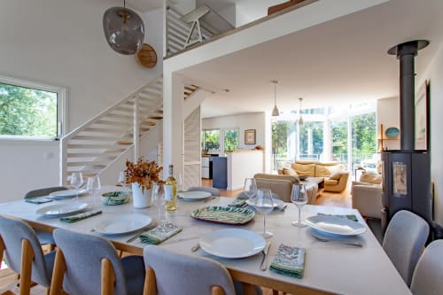 Spacieuse salle à manger de la Villa Cloudbreak à La Loge Du Bassin, Lège Cap Ferret, avec foyer moderne et vue sur l'océan