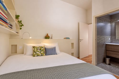 Chambre moderne à la Villa Cloudbreak : literie blanche, oreillers à motifs, salle de bain attenante, près de Lège Cap Ferret