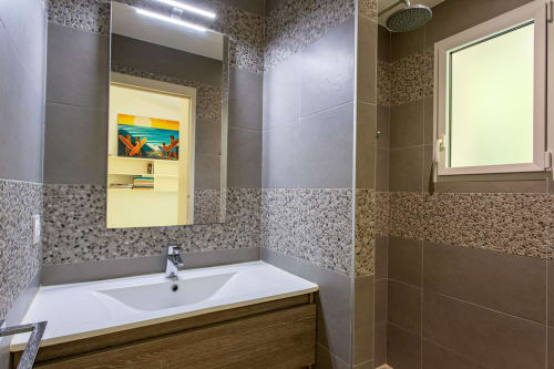 Salle de bains moderne à la Villa Cloudbreak à Lège Cap Ferret avec murs carrelés, lavabo blanc, grand miroir et douche vitrée