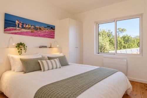 Chambre moderne et lumineuse avec coussins verts et blancs, plantes et grandes fenêtres donnant sur le jardin de Villa Cloudbreak, Lège