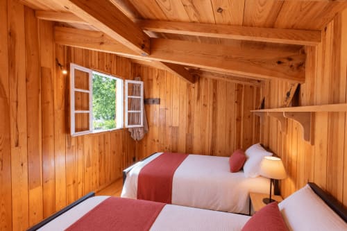 Chambre cosy avec deux lits et accents rouges à la Villa Cloudbreak, Lège Cap Ferret
