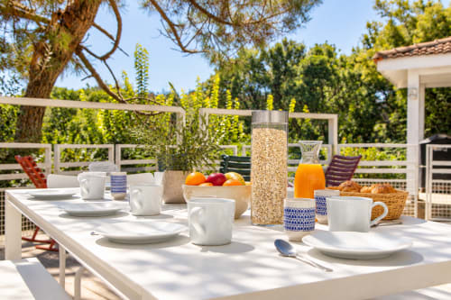 Petit-déjeuner en plein air à la Villa Cloudbreak, vaisselle blanche et jardins verdoyants à Lège-Cap-Ferret