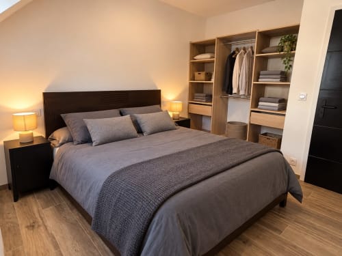 Chambre moderne à Le Hangar 7, Breizh Guilvinec : lit king-size, armoire en bois et éclairage chaleureux