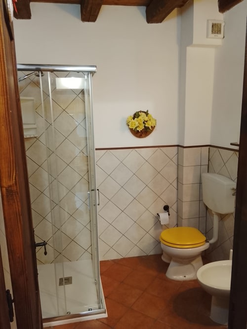 Bagno dell'Appartamento Giallo a Case Vacanze Borgo i Stritti, Petralia Soprana, con sedile wc giallo e doccia walk-in