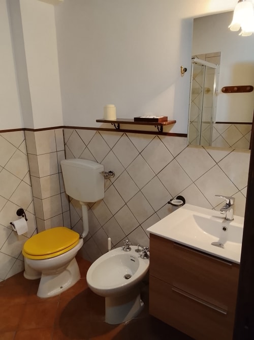 Bagno dell'Appartamento Giallo presso Case Vacanze Borgo i Stritti, Petralia Soprana, con wc giallo, bidet e lavandino
