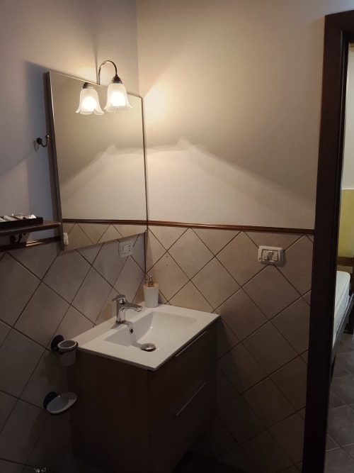 Lavabo del bagno con specchio e due applique murali nell'Appartamento Giallo di Case Vacanze Borgo i Stritti, Petralia Soprana
