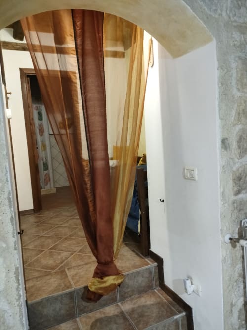 Ingresso del corridoio dell'Appartamento Giallo presso Case Vacanze Borgo i Stritti, Petralia Soprana, con arco e tende
