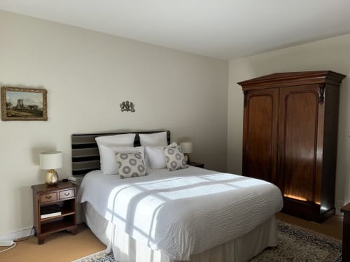 Elegant bedroom at Domaine de Bize Mirepoix with queen bed, wooden wardrobe, and classic furnishings