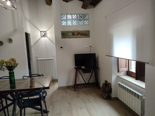 Ampio soggiorno a Case Vacanze Borgo i Stritti a Petralia Soprana con arredamento moderno, TV e grandi finestre