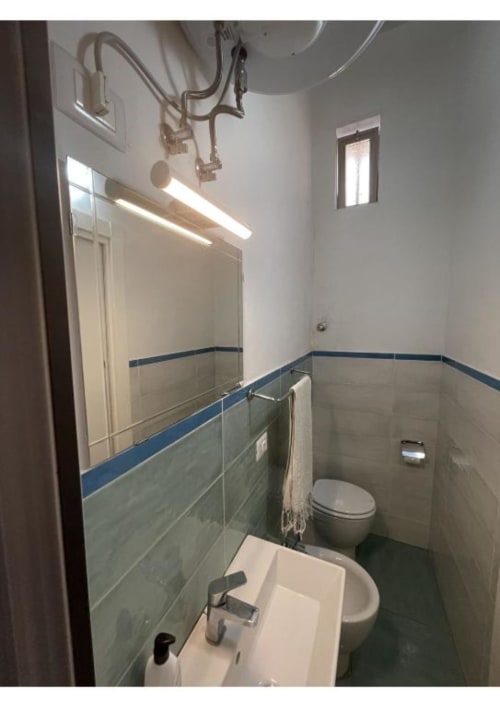 Bagno moderno nell'appartamento Casa Ida a Vietri sul Mare con lavabo bianco, toilette, bidet e piastrelle blu