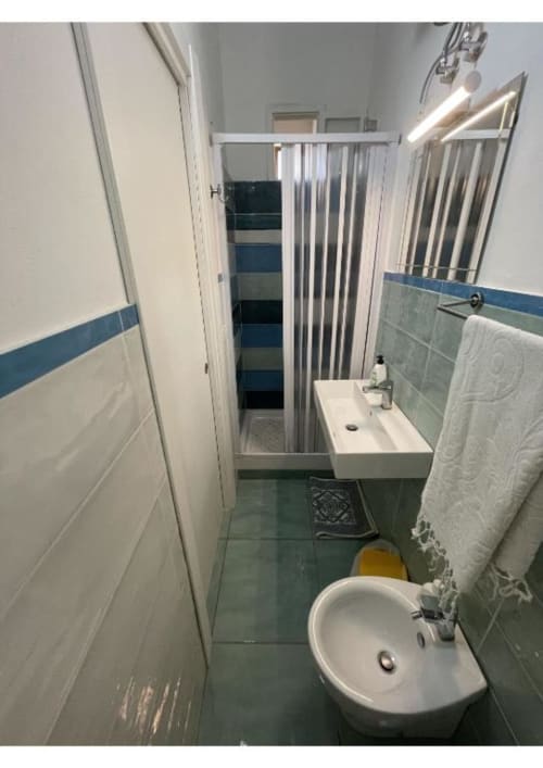 Bagno moderno di Casa Ida 2 a Vietri sul Mare con lavabo bianco, bidet, doccia e dettagli in piastrelle blu