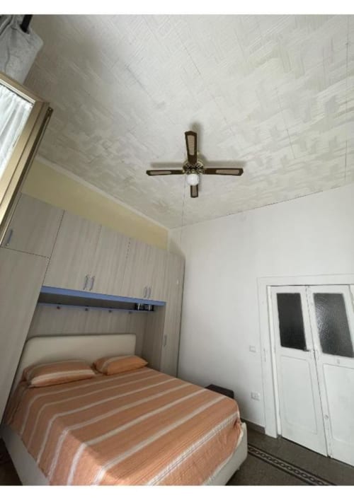 Camera da letto in Casa Ida 2 a Vietri sul Mare con letto, ventilatore a soffitto, armadio e pareti bianche