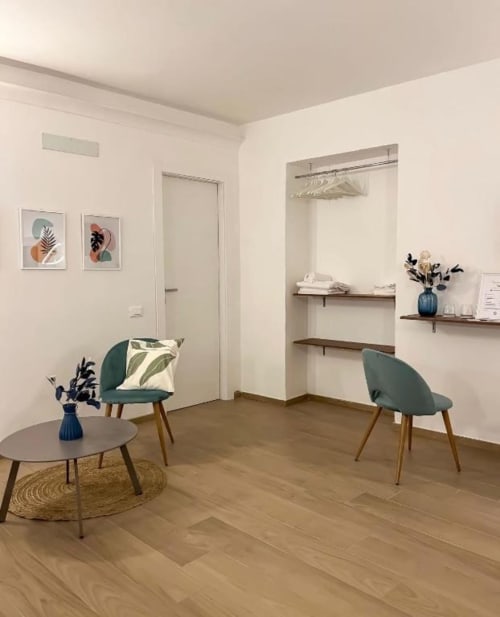Camera moderna della Casa Ida B&B a Vietri con sedie turchesi, pavimenti in legno e arredamento botanico