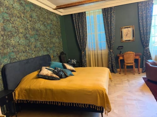 Chambre deluxe à la Maison Crone B&B à Castillon-en-Couserans avec lit jaune, papier peint damassé et rideaux élégants