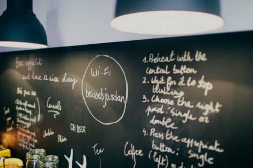Panneau de menu du Brussels B&B affichant les détails Wi-Fi et Brussels Bourdan avec instructions manuscrites pour le café et la bière