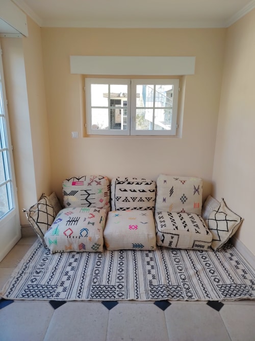 Coin cosy avec coussins à motifs et tapis géométrique à la chambre Soleil levant 2, Domaine Chapelle B&B