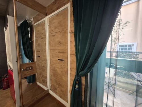 Armadio in legno e tende verdi nell'appartamento Nidus di Giulia a Babaja Roma, con balcone vista città