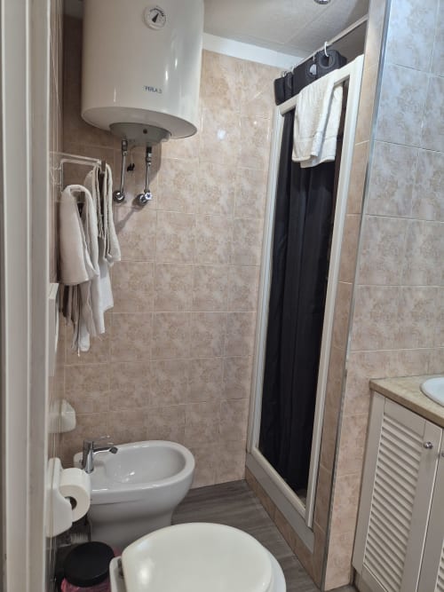 Bagno compatto presso l'alloggio Babaja a Roma con toilette, bidet, doccia e scaldabagno a parete