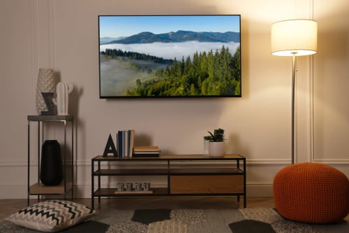 Salon moderne à La Grange Aux Etangs avec écran TV paysage montagneux, meuble TV en bois et éclairage chaleureux